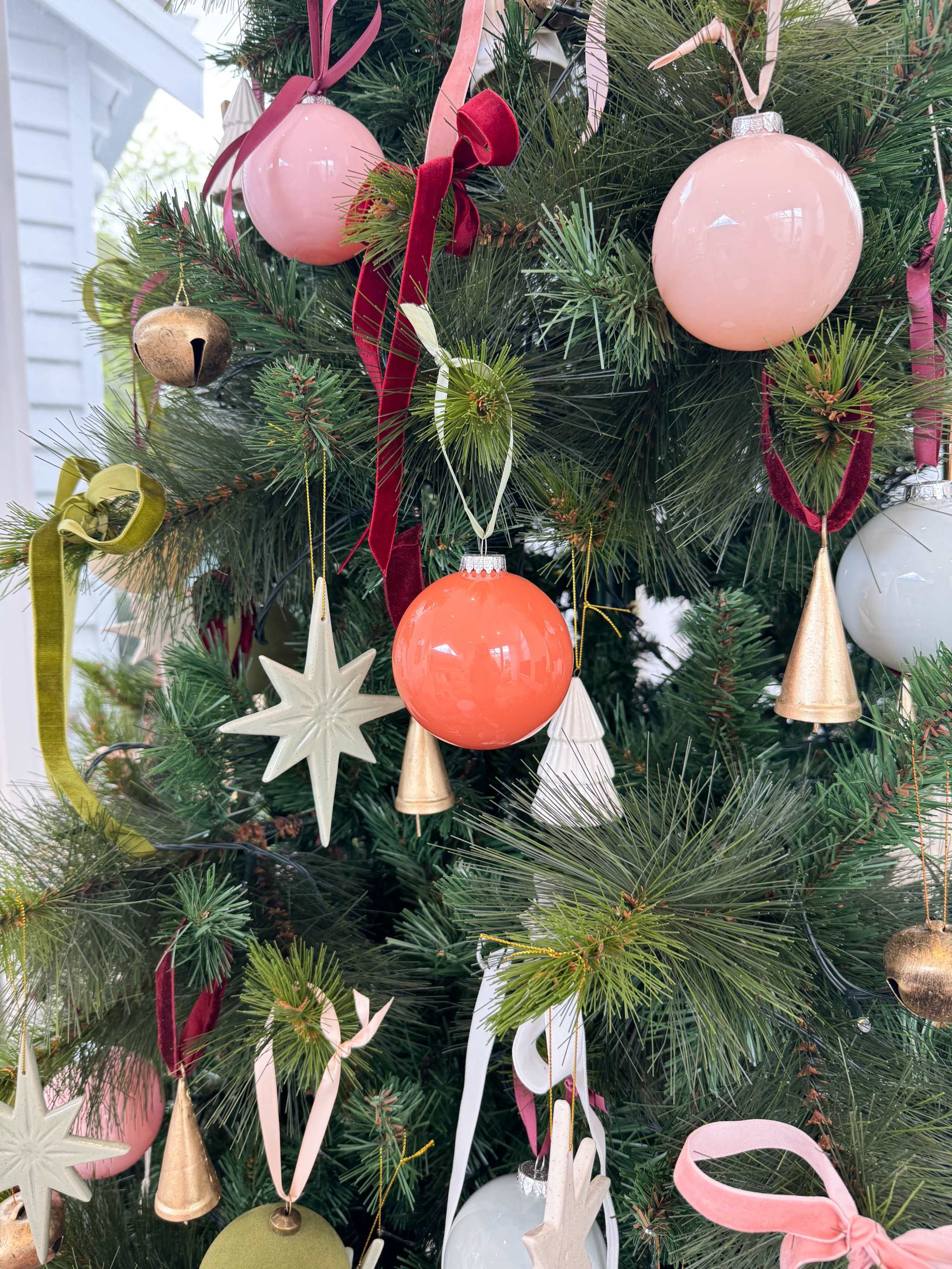 norsu STUDIO Glass Christmas baubles with velvet ribbon on tree in tomato and coral shades
