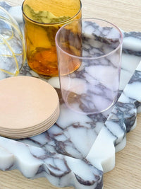 Palazzo Marble Tray with scalloped edges in Viola marble holding glassware and coasters on wooden surface