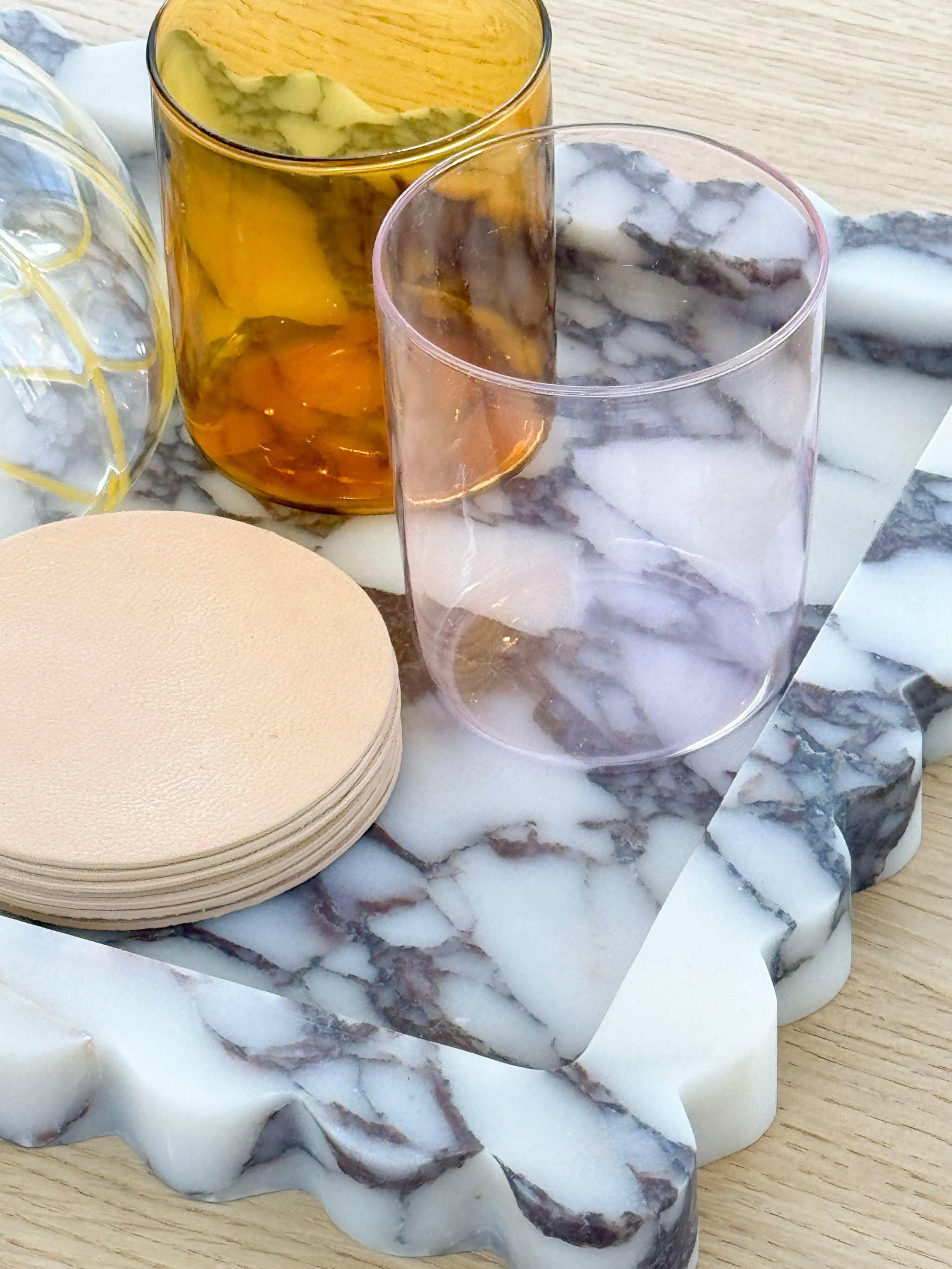 Palazzo Marble Tray with scalloped edges in Viola marble holding glassware and coasters on wooden surface