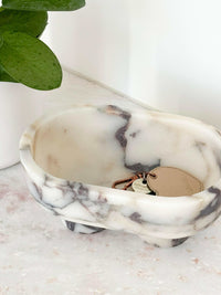 CoTheory Marble Footed Oval Tray in Viola Marble with sculptural design and small feet holding keys and a keychain on marble surface