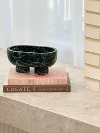 CoTheory Marble Footed Oval Tray in Verdi Alpi green stone with sculptural design on books by window