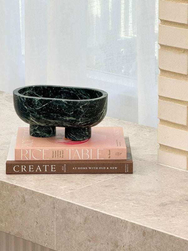 CoTheory Marble Footed Oval Tray in Verdi Alpi green stone with sculptural design on books by window