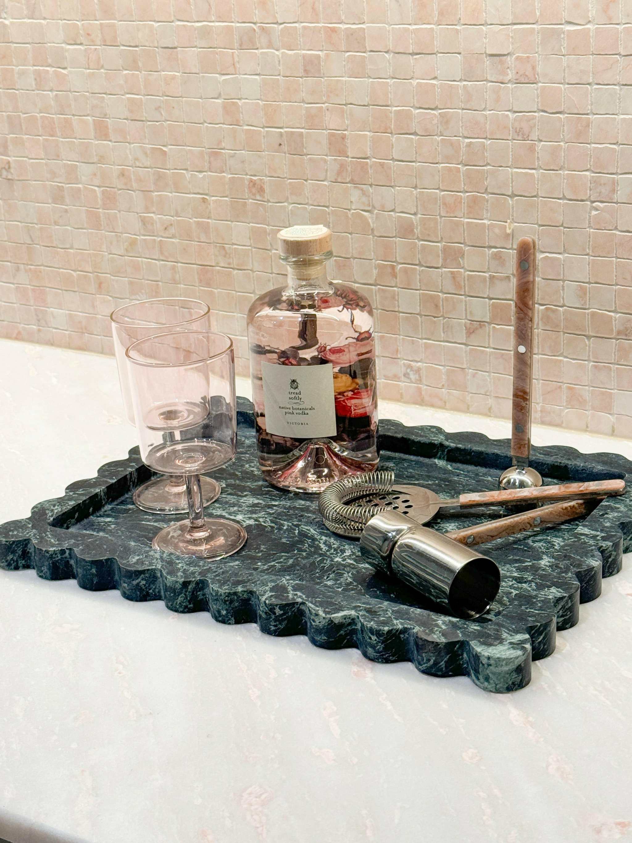 CoTheory large scalloped marble tray in Verdi Alpi with bar tools and glass on countertop