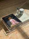 norsu Studio scalloped clear perspex tray holding books and decor on marble surface