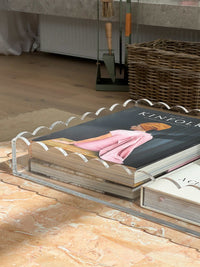 norsu Studio scalloped edge clear perspex large rectangular tray with stylish books on marble surface