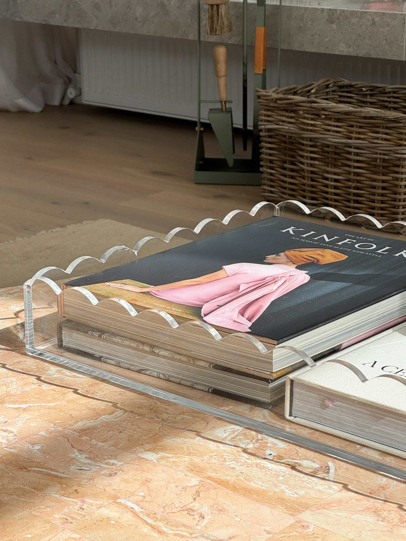 norsu Studio scalloped edge clear perspex large rectangular tray with stylish books on marble surface