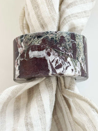norsu STUDIO Marble Circular Napkin Ring in Rosso Levanto deep burgundy with white veining on striped linen napkin