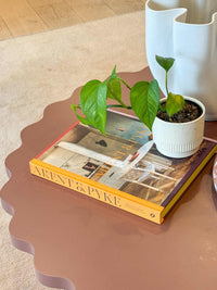 Arent & Pyke interior design book with plant on scalloped edge table