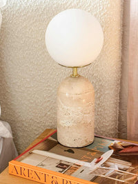 Arent & Pyke styled marble table lamp with globe shade on textured fabric and design books
