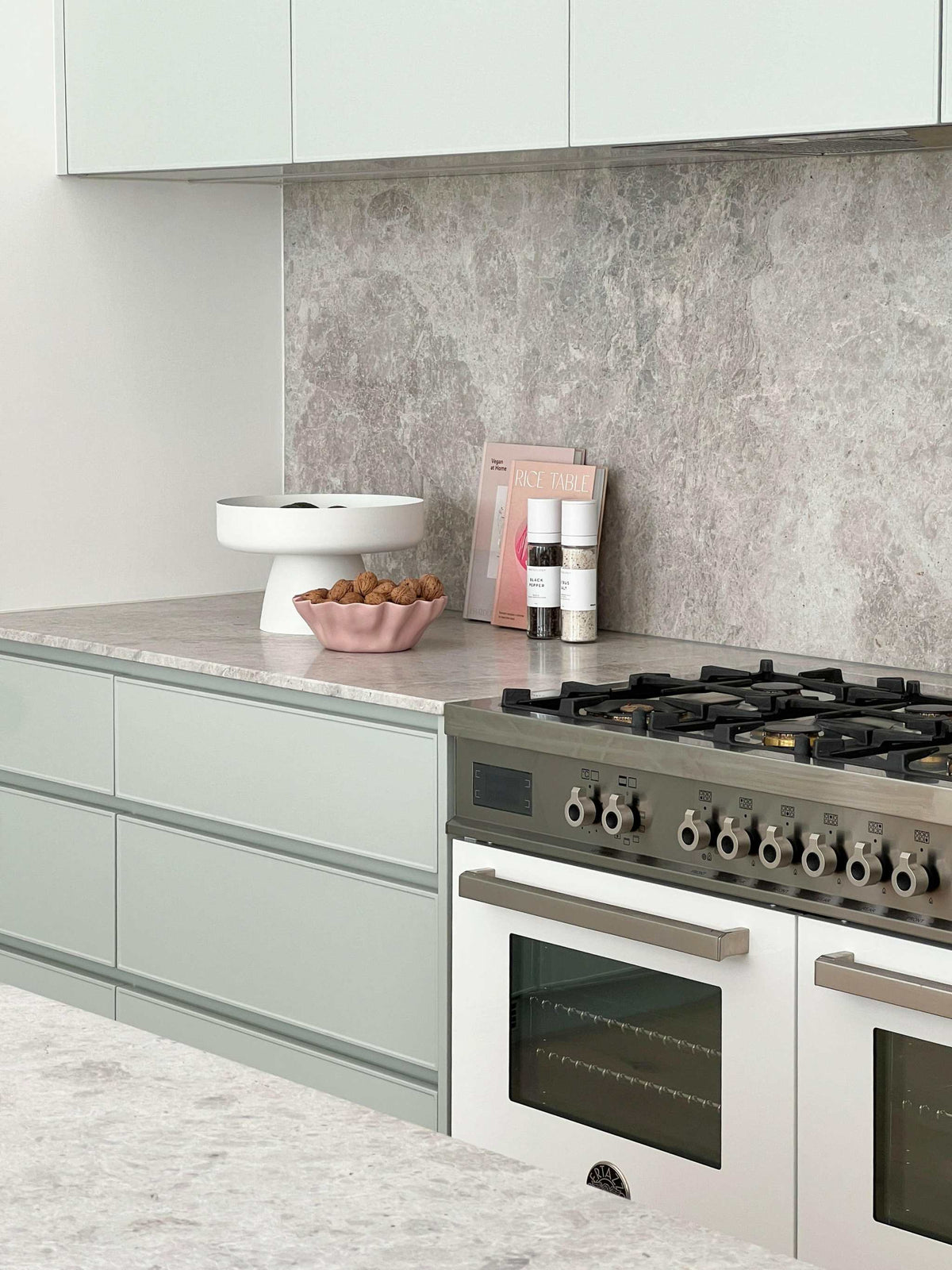 Modern kitchen bench styled with decorative objects, cookbook, and spices for a professional look