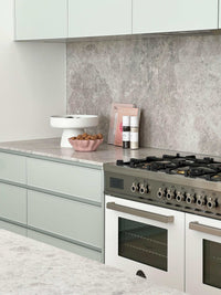 Modern kitchen bench styled with decorative objects, cookbook, and spices for a professional look