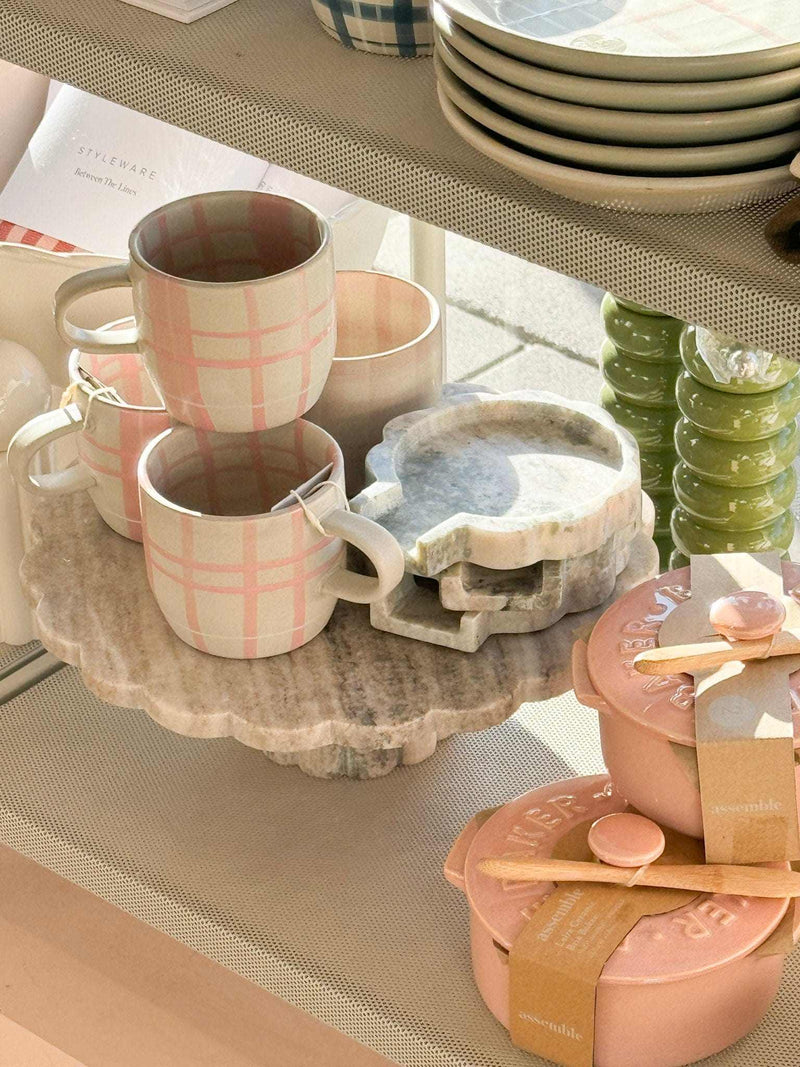 Robert Gordon Hand-Painted Mug with pink tartan pattern stacked on marble tray alongside ceramic cookware and dishes