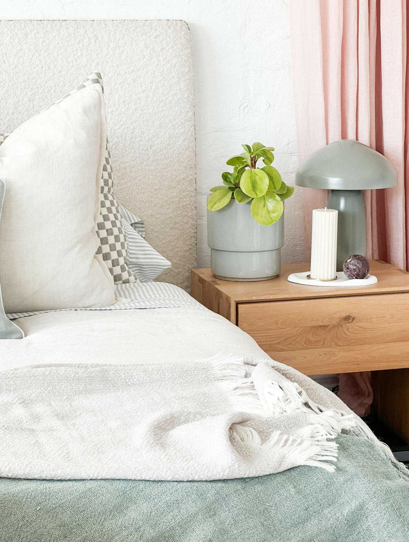 Easton Curve Lamp with Pantone Elm iron base on wooden bedside table in cozy bedroom setting