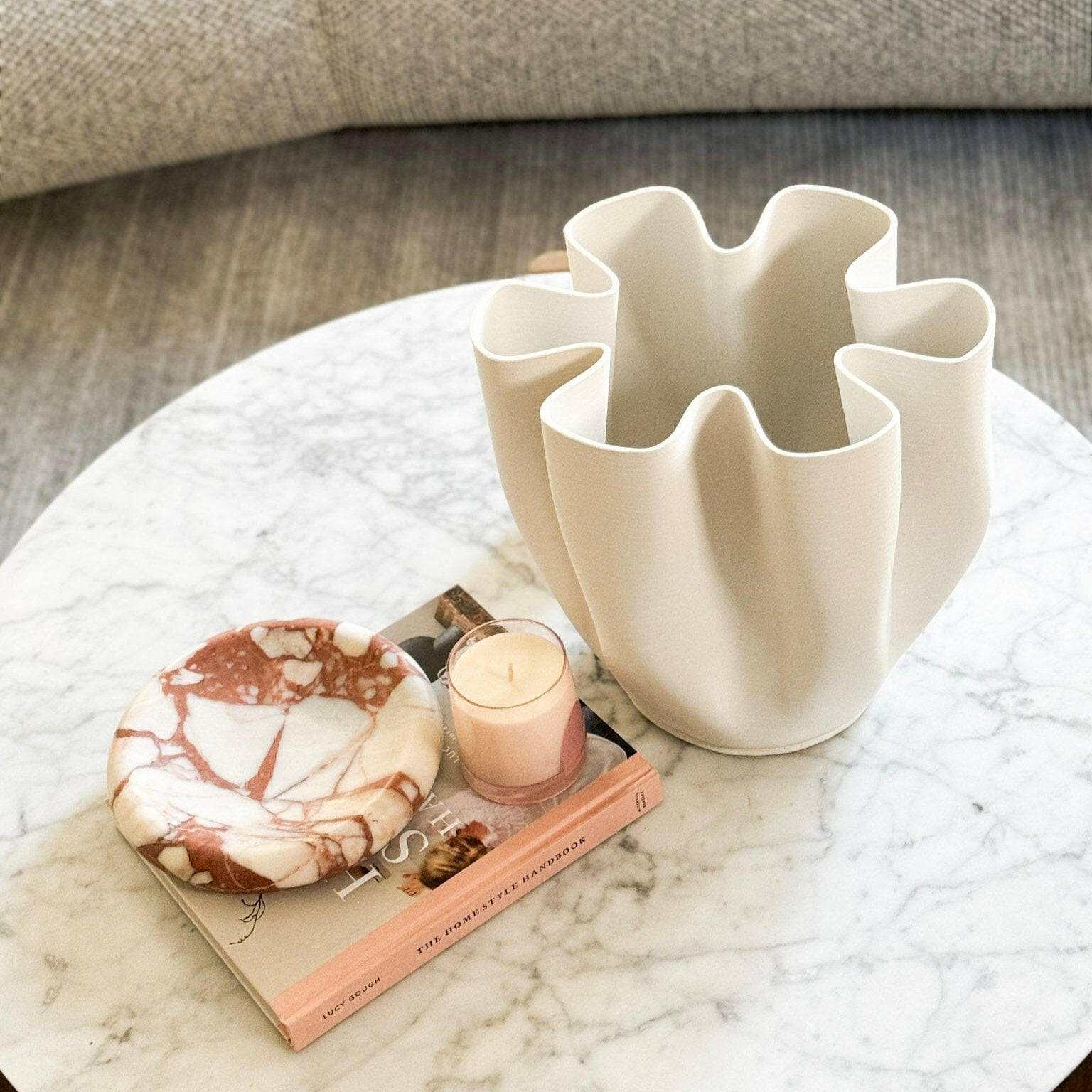 CoTheory small brown Calacatta marble tray with sculpted curves on marble table
