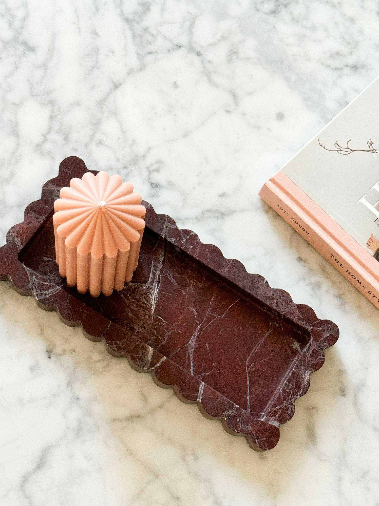 CoTheory Rosso Levanto scalloped marble bar tray on marble surface with candle and book