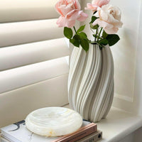 CoTheory Onyx Tray Solstice small white onyx round sculpted tray on books near vase with pink roses