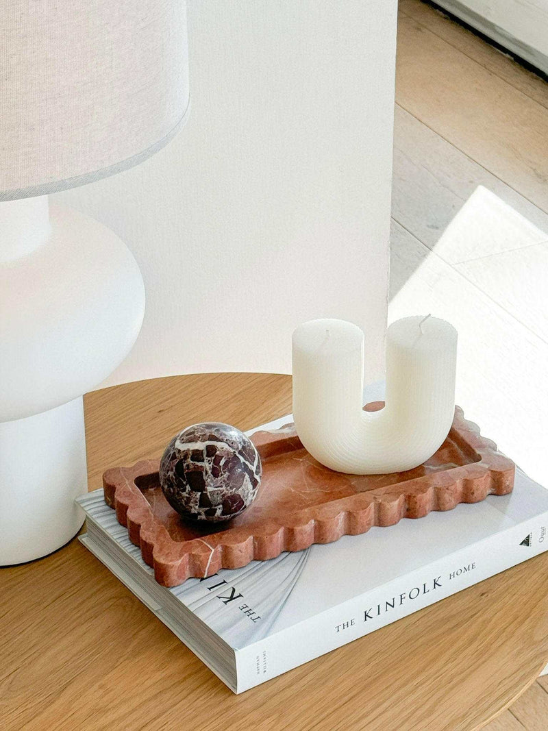 Palazzo Scalloped Marble Tray in Rosso Alicante with decorative objects on wooden table next to white lamp