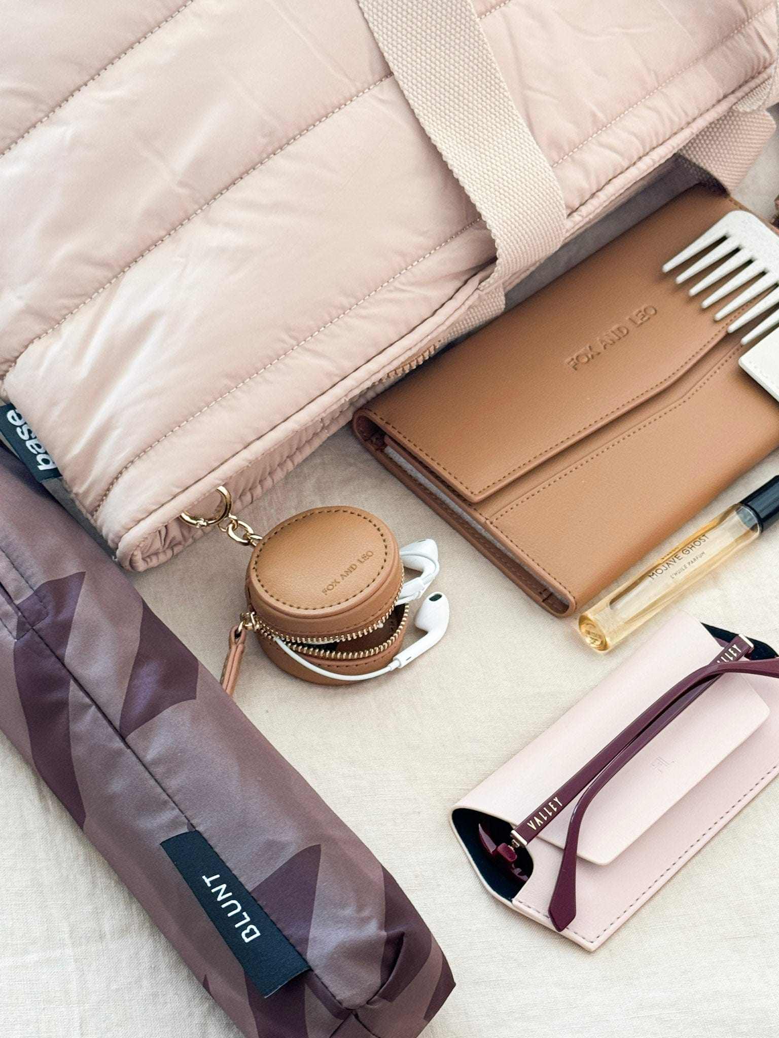 Fox and Leo Eye Catcher Bag Charm in tan leather with gold hardware and microfibre cleaning cloth attached to a beige bag strap.