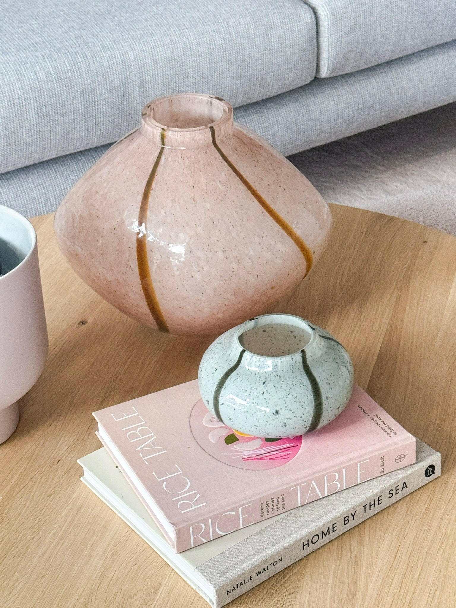 GlobeWest Boden Stripe Bud Vase in sage green handblown glass with stripe pattern on coffee table