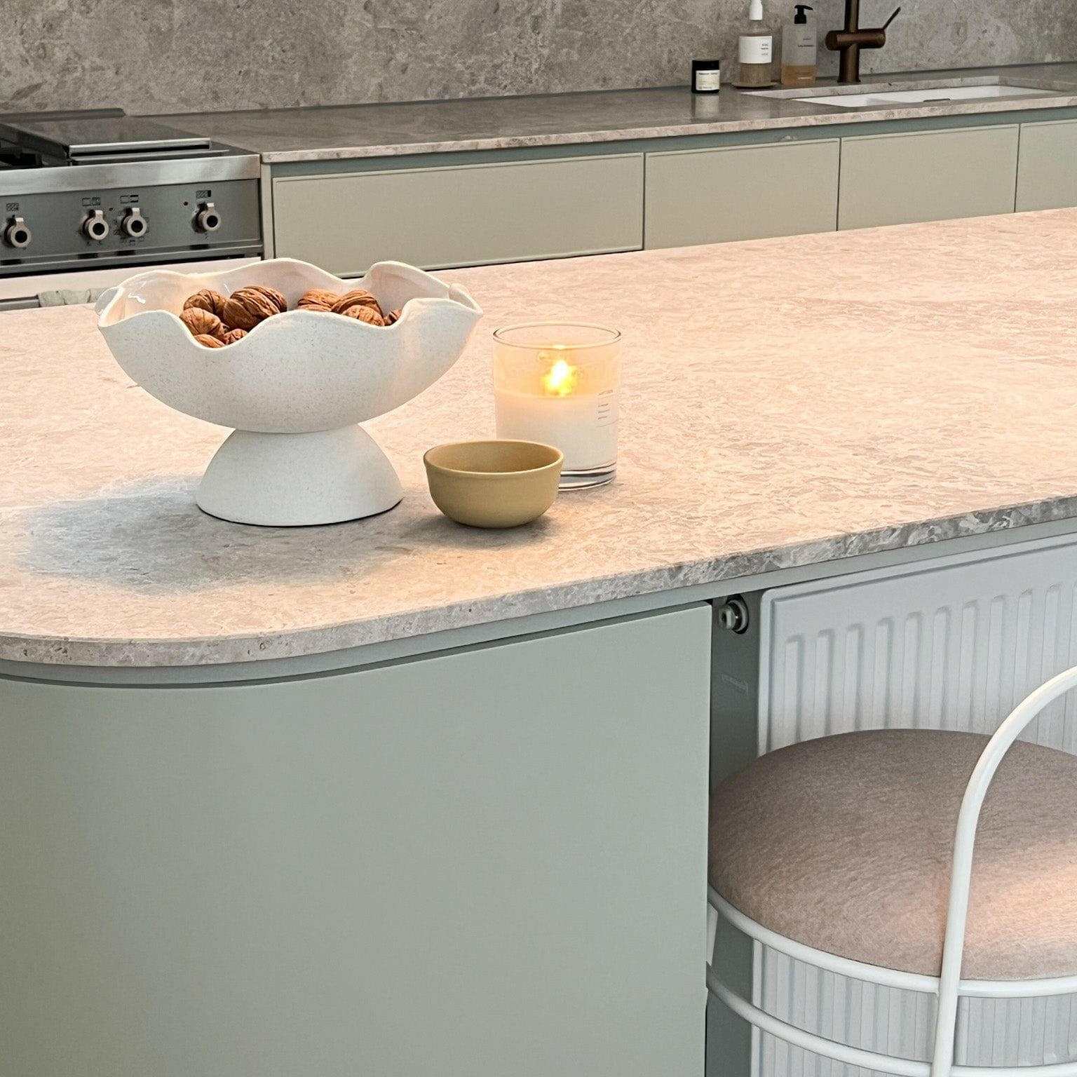 Ripple White Pedestal Bowl with glossy interior and textured exterior holding walnuts on kitchen countertop