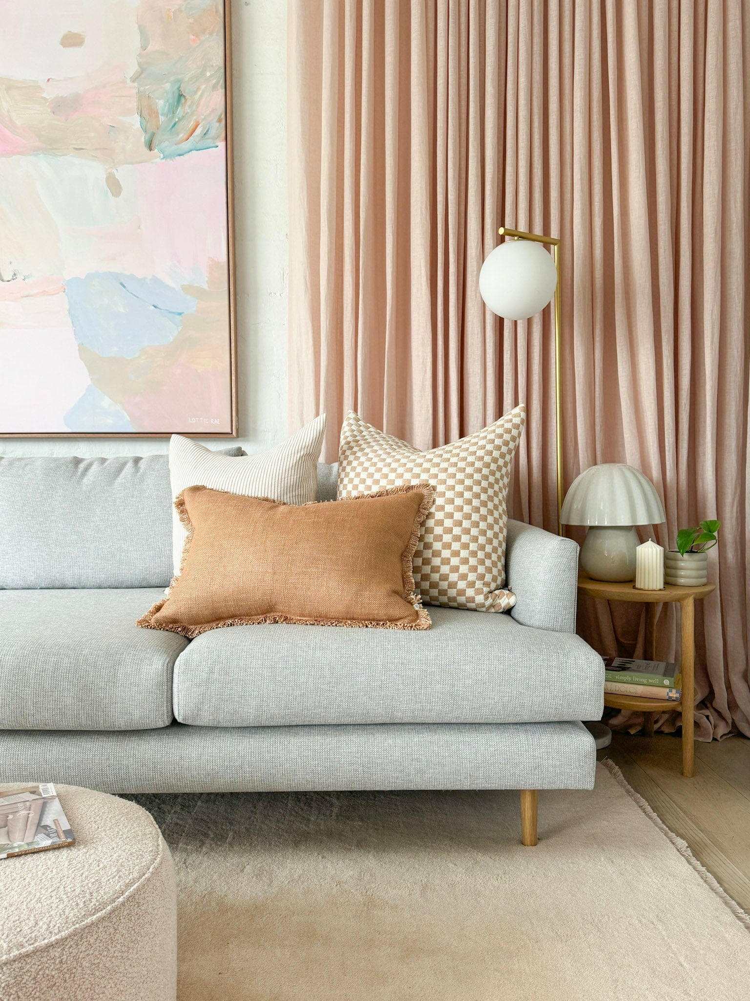 Baya Dover Cushion nude lumbar pillow with soft fringed edges on light gray sofa in modern living room setting