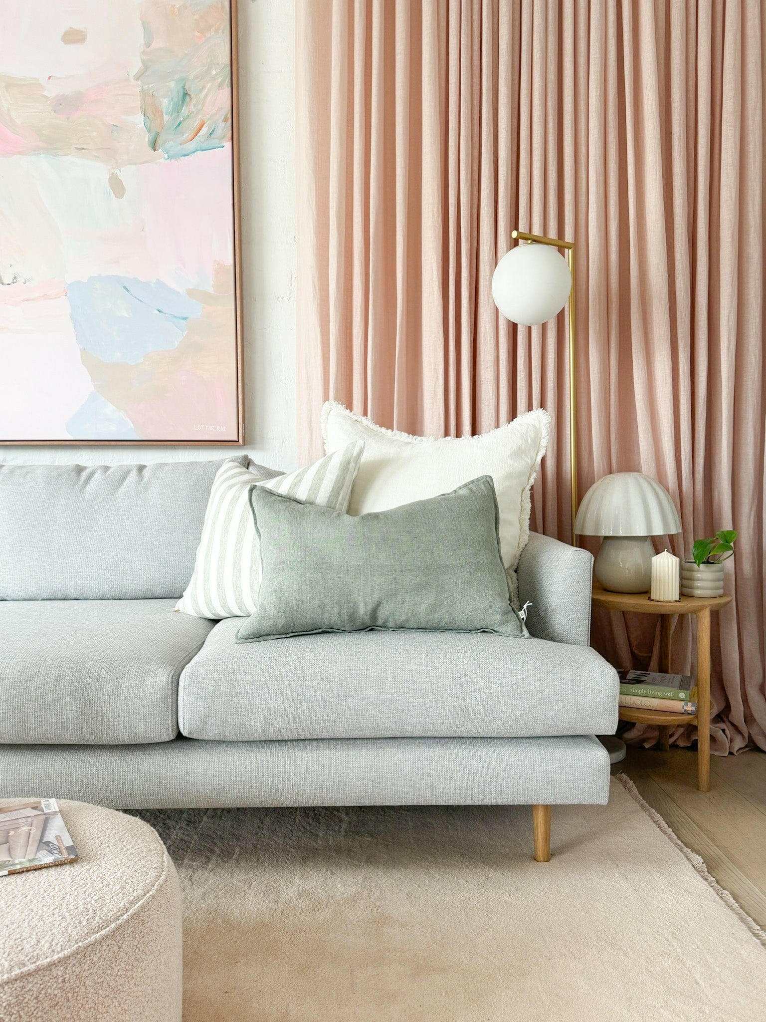 Baya Arcadia Cushion in Sage linen on modern grey sofa with pink curtains and decorative pillows
