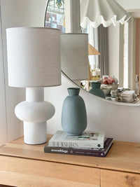 GlobeWest Hanson Kylo Vessel in Moonstone granite handcrafted earthenware ceramic vase on wooden table next to white modern lamp and books