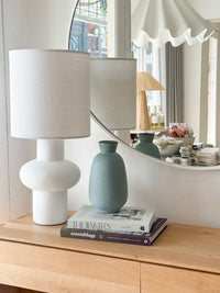 GlobeWest Hanson Kylo Vessel in Moonstone granite ceramic displayed on wooden surface next to white modern lamp and round mirror