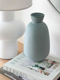 GlobeWest Hanson Kylo Vessel in moonstone granite ceramic placed on books next to a white lamp