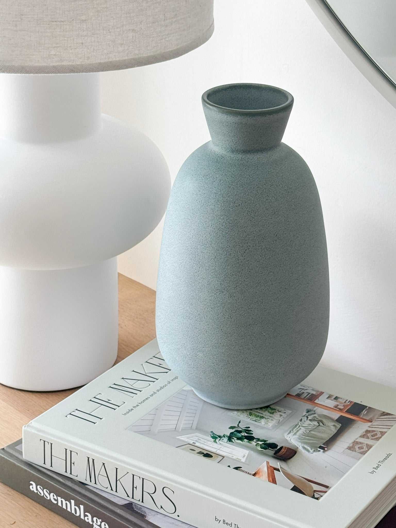 GlobeWest Hanson Kylo Vessel in moonstone granite ceramic placed on books next to a white lamp