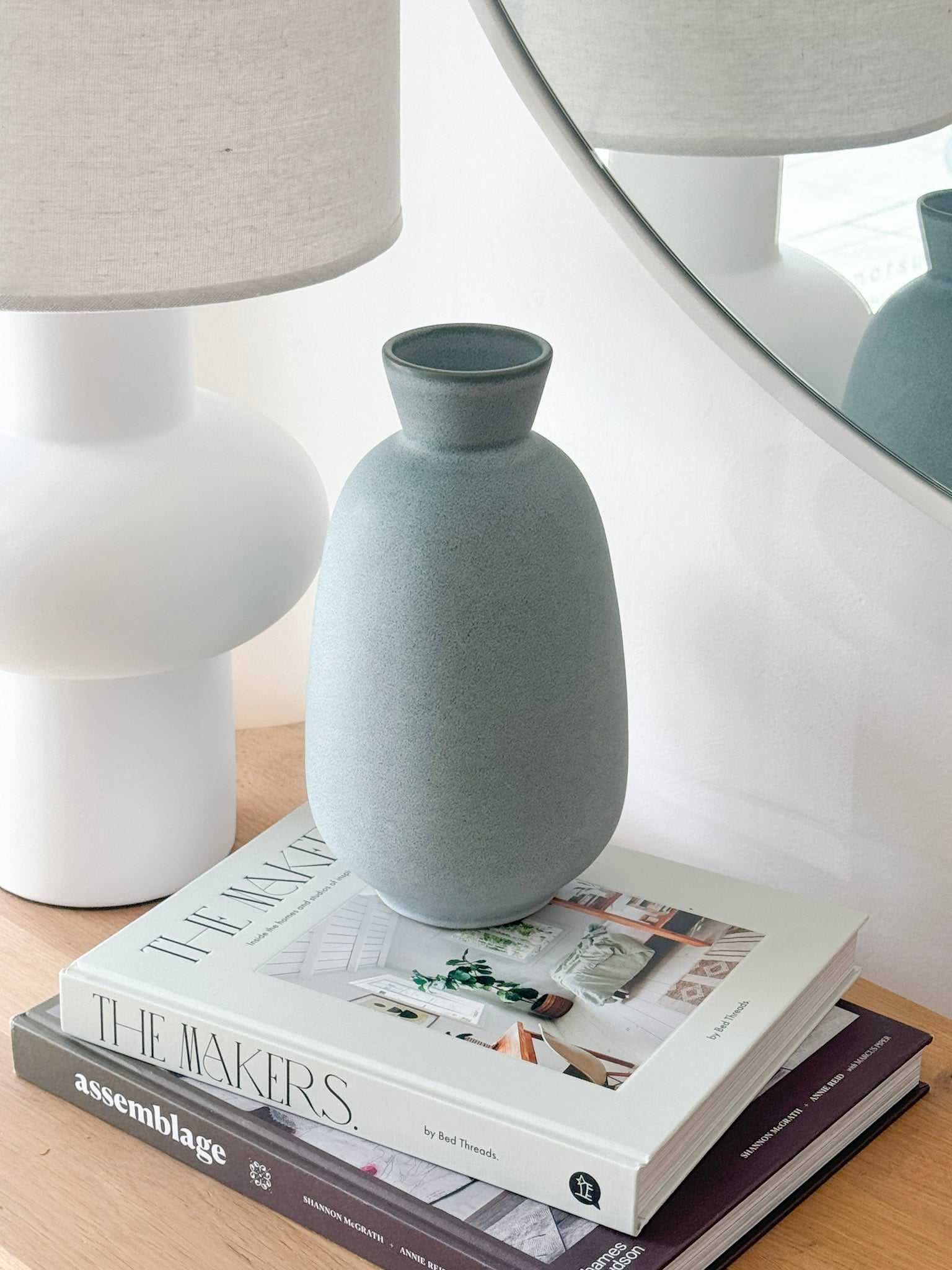 GlobeWest Hanson Kylo Vessel in moonstone granite ceramic finish on stacked books by lamp and mirror indoors