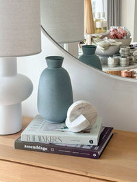 GlobeWest Hanson Kylo Vessel in moonstone granite ceramic with classic shape on wooden table next to white lamp and decorative books