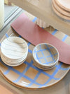 Stack of Coastal Junction Condiment Bowls with blue check and linear stripe designs on a matching large platter