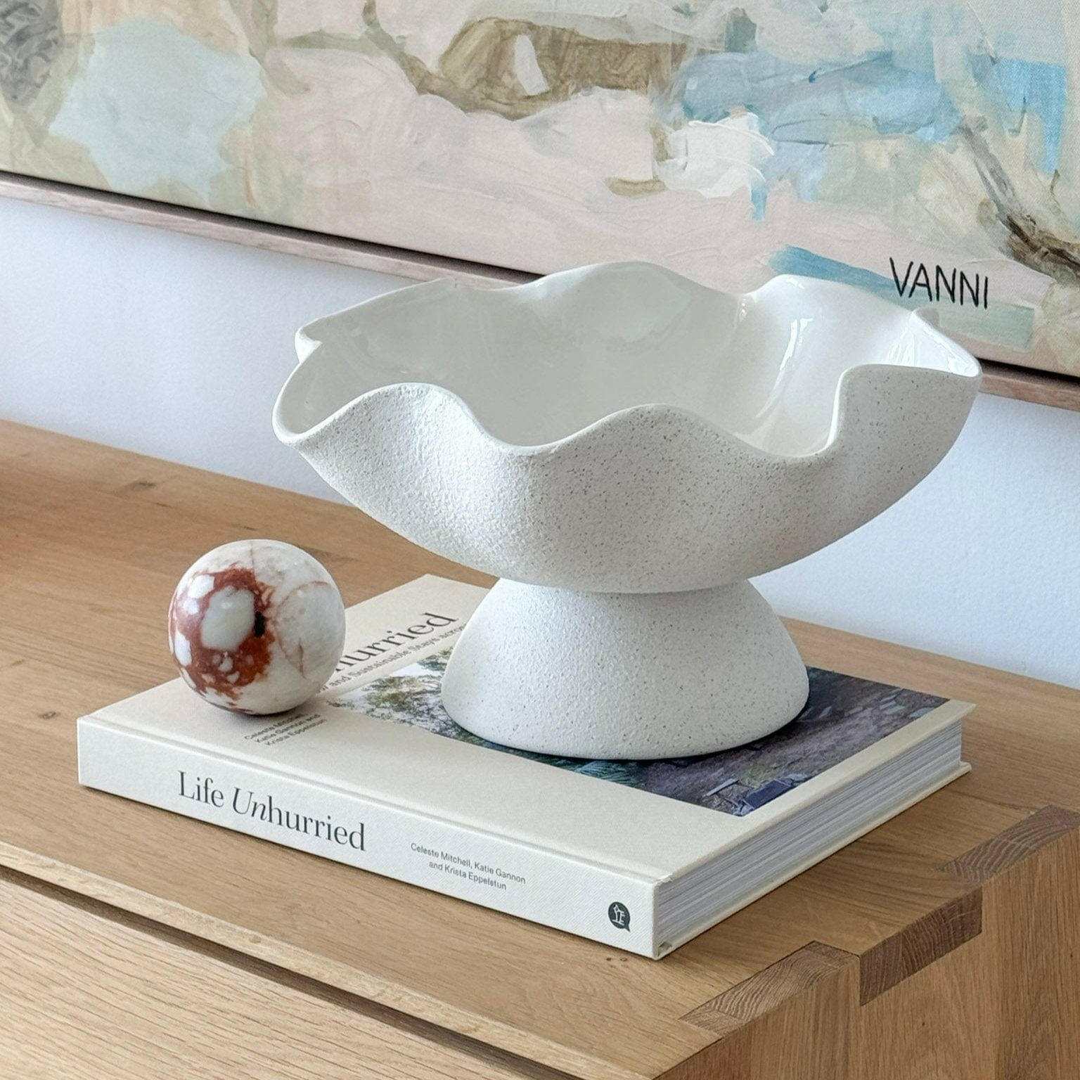 Ripple White Pedestal Bowl ceramic with wavy textured exterior and glossy interior on wooden surface.