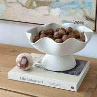 Ripple White Pedestal Bowl ceramic fruit bowl with textured exterior filled with walnuts on a wooden table.
