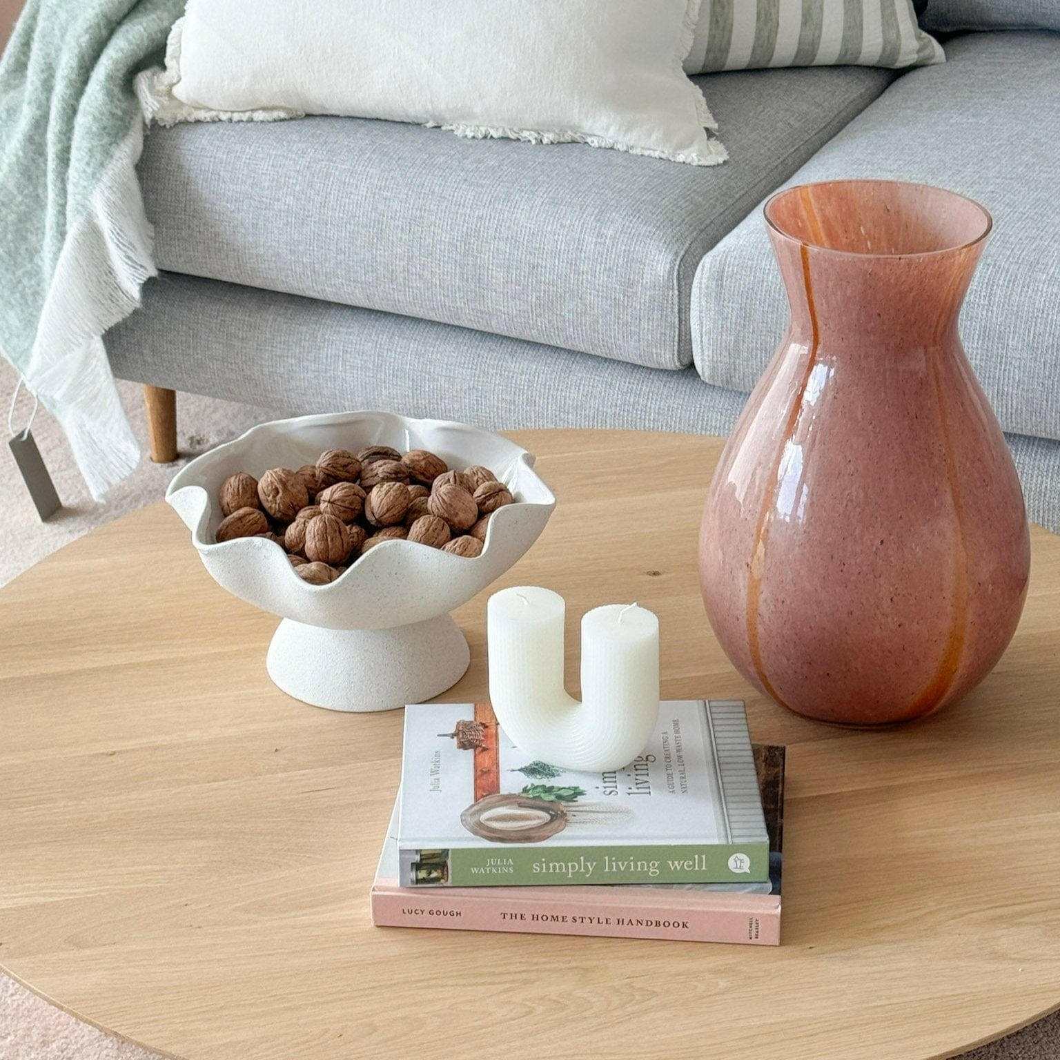 Ripple White Pedestal Bowl ceramic with glossy interior and textured exterior holding walnuts on wooden table in modern living room setting