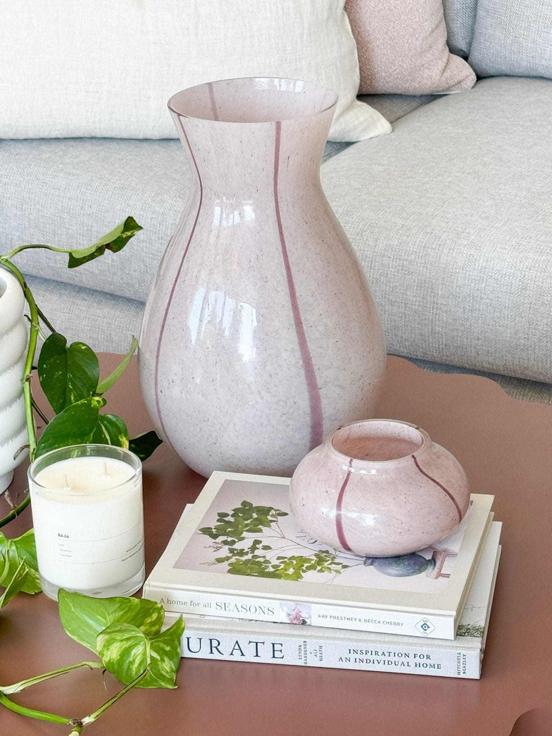 GlobeWest Boden Stripe large lilac handblown glass vase with delicate stripes, styled on a table with plants and books.