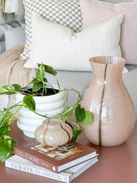 GlobeWestBoden Stripe tall blush vase with delicate stripe pattern on a table next to small vase and plant pot