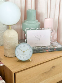Maisie Silent Tick Alarm Clock green vintage style with gold accents on wooden bedside table