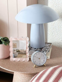 Maisie Silent Tick Alarm Clock in grey with gold accents and Arabic numerals on bedside table