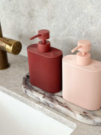 Rose-colored Rosie resin dispenser with ridged grip for bathroom and kitchen refill use