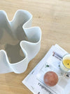 Bailey Decorative Vase white matte ceramic with elegant wavy design on wooden table next to candle and magazine