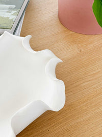 White Lottie Decorative Bowl with ruffled edges and matte finish on wooden surface