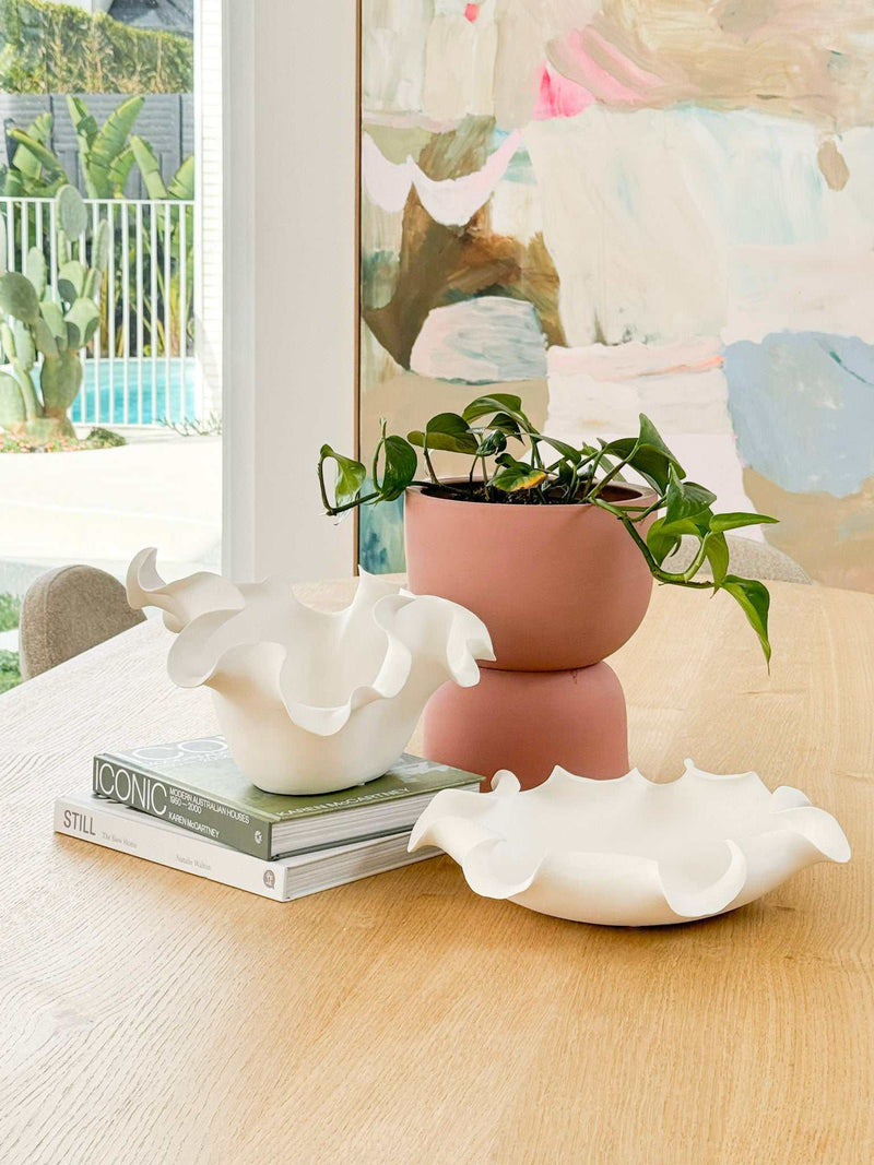 Lottie Decorative Bowl white ceramic with ruffled edges and matte finish displayed on wooden table with plant pots and books