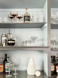 CoTheory Orbit Table Sculpture small white onyx sphere on shelf with glassware and bottles