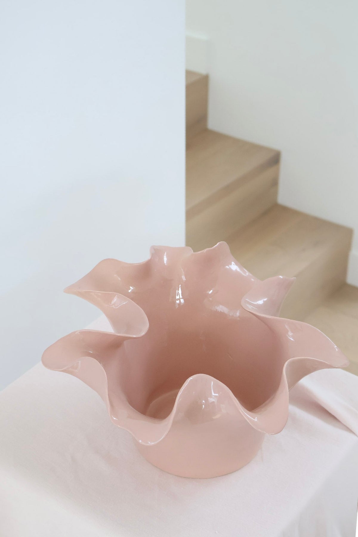 norsu Studio Flow sculptural ceramic bowl in muted blush with ruffled edges and glossy finish
