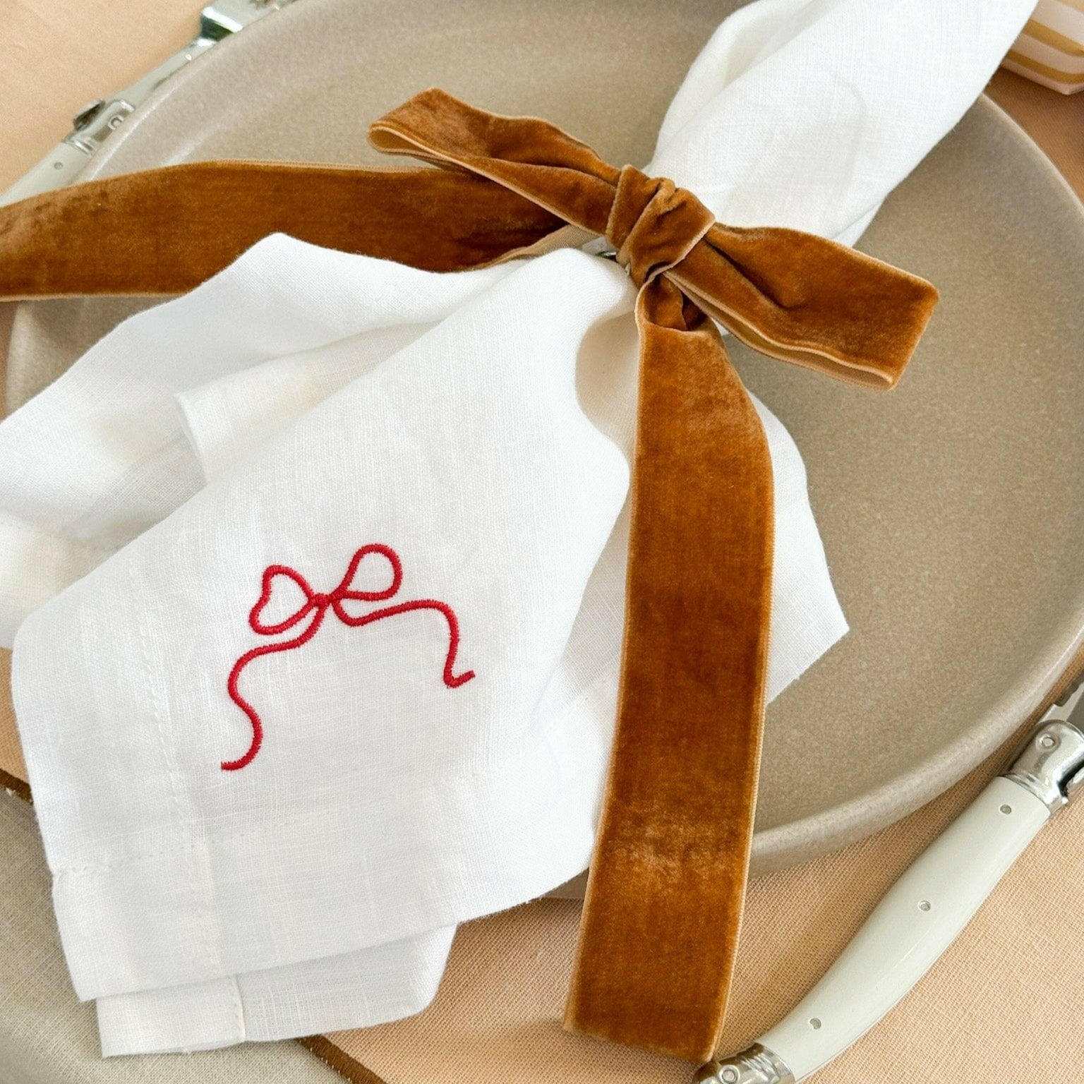 Caramel velvet Same Time Tomorrow napkin ring tied around white napkin on beige plate