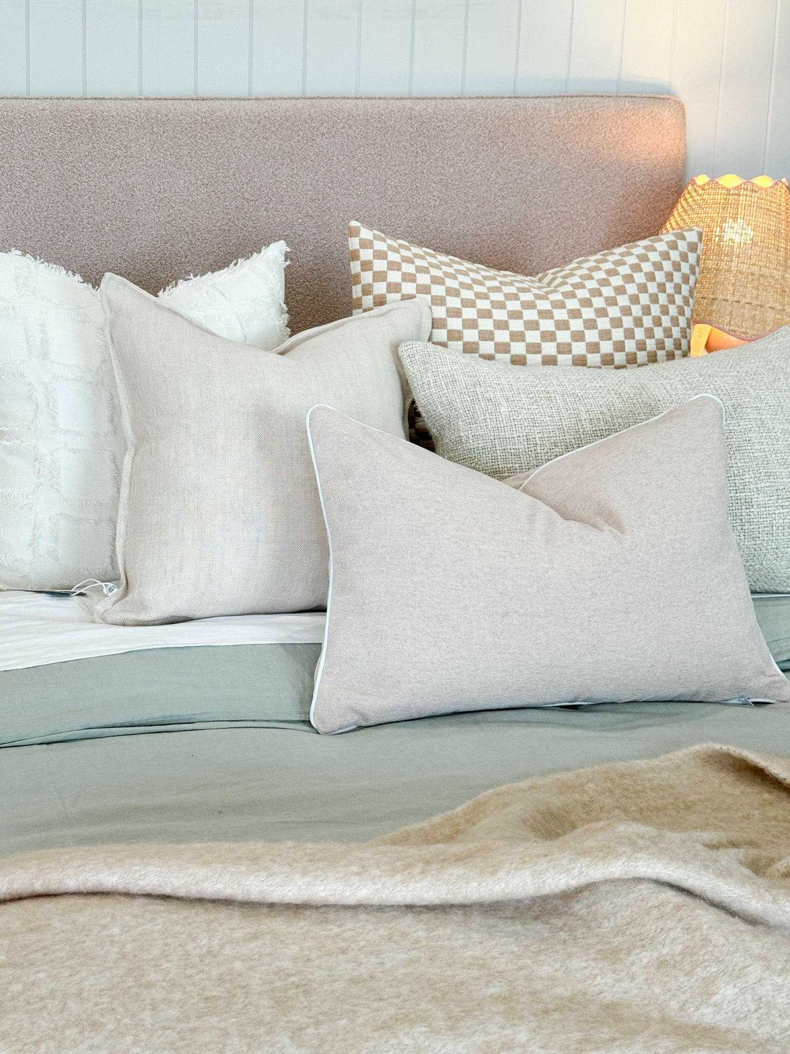 Handmade norsuHOME Cushion Parissi Shell in neutral tones with feather down filling on a bed setting