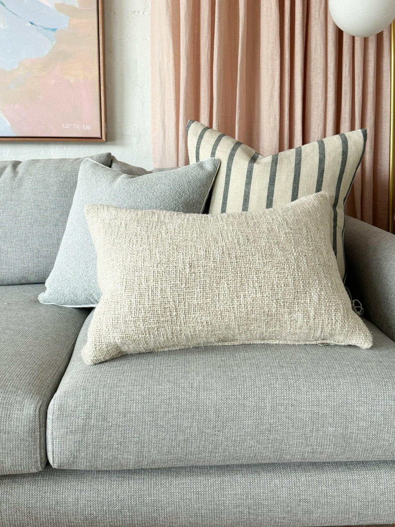 Baya Cyprian Oblong Cushion in oatmeal, textured soft yarn lumbar pillow on grey sofa