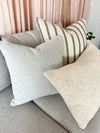 Baya Cyprian Oblong Cushion in oatmeal with soft textured yarn on a grey sofa with other cushions